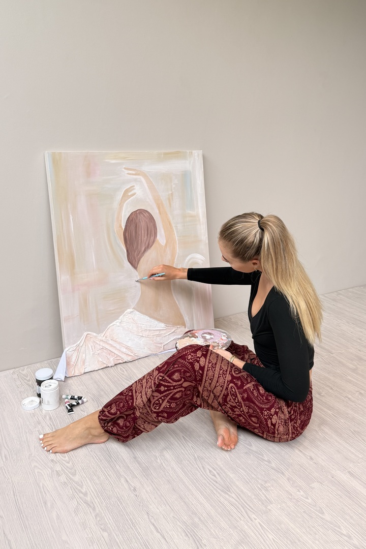 Creator painting while wearing red patterned pants